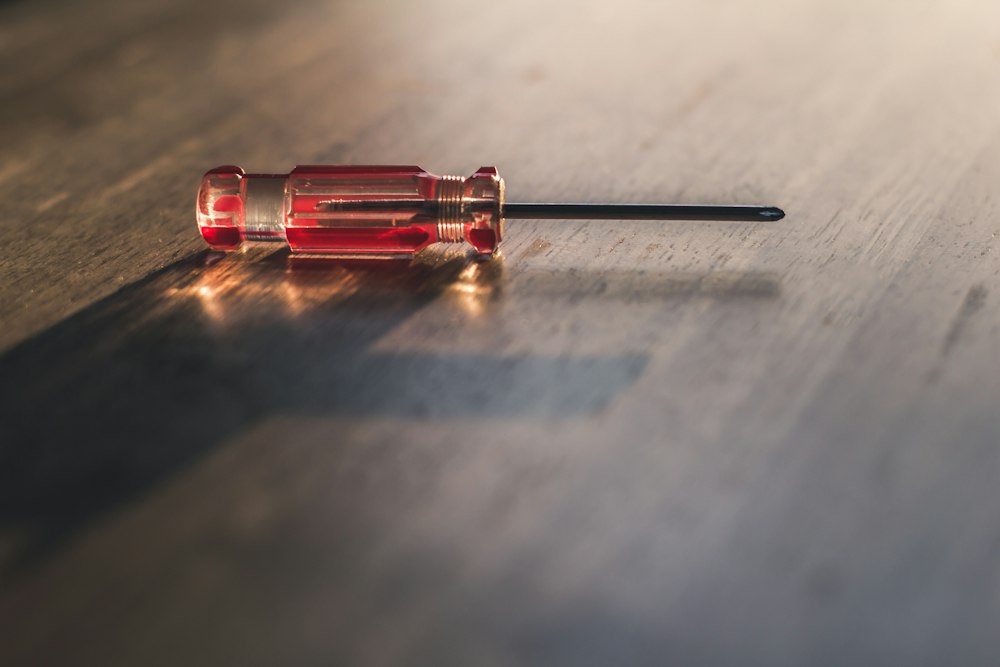 Destornillador de mango rojo sobre una mesa de madera